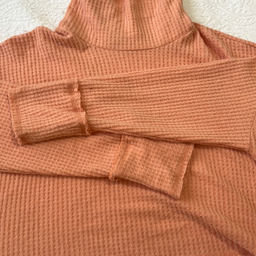 Coral sweater. Not too thick. Elastic. A little short